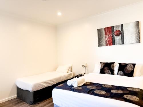 two beds in a room with white walls at city unit at gouger st in Adelaide