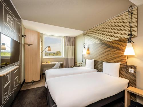 a hotel room with two beds and a window at ibis Bern Expo in Bern