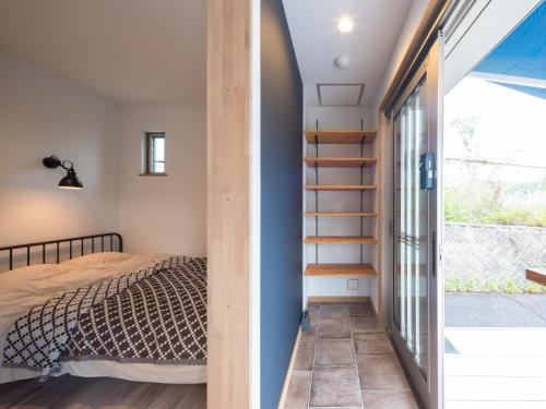 a bedroom with a bed and a staircase next to a window at Mobile Home 8 in Hokuto