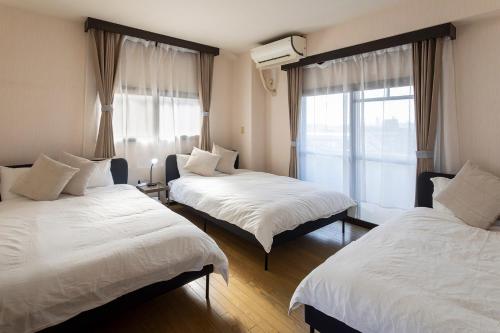 a bedroom with two beds and a window at La Pace Awaji in Osaka