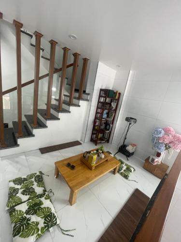 a living room with a wooden table and stairs at Homestay giữa trung tâm Hải Phòng in An Dương