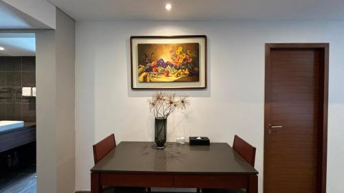a dining room table with a vase of flowers on it at Manior PentStudio West Lake Accomadi in Hanoi