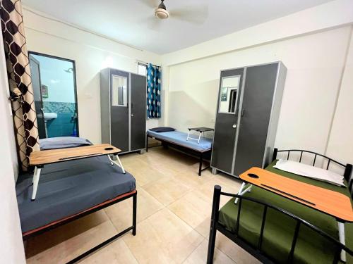 a room with two bunk beds and two benches at Alpine Hostel Services in Pune