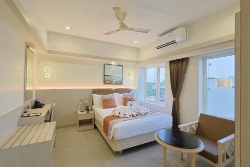 a bedroom with a bed and a chair and a window at Sree Bharani Hotels in Tirunelveli