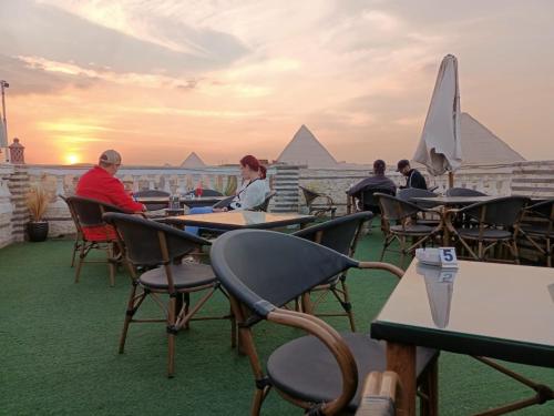 a group of people sitting at tables on a roof at Pyramids Stars Egypt in Cairo