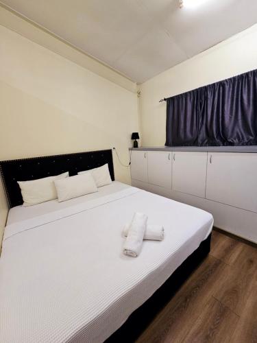 a bedroom with a bed with two towels on it at Aurora Mirage Apartments in Nadi