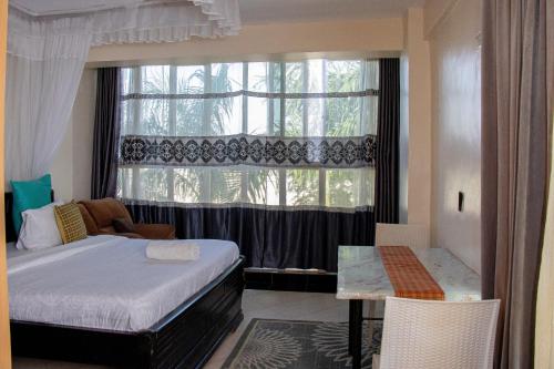 a bedroom with a bed and a large window at ACARA HAVEN Kisumu in Kisumu