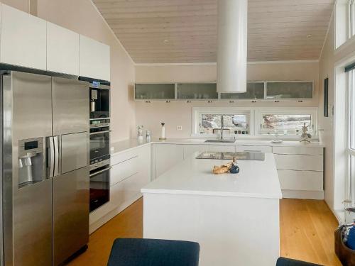 a kitchen with white cabinets and stainless steel appliances at Seaside Cabin With Private Pier In Eidsvåg in Eidsvåg