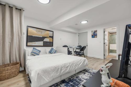 a bedroom with a white bed and a dining room at Bunny Bliss - Lower Level HotTub FirePit Theatre in Langley