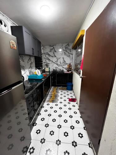 a kitchen with a black and white tiled floor at D Alamanda Homestay in Kampong Kapinan