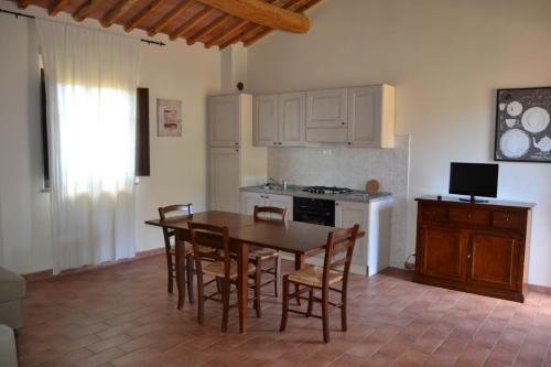 a kitchen with a table and chairs and a stove at Antico Borgo Casalappi in Campiglia Marittima