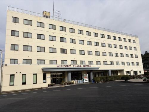 a large white building with an airport trial room at Airport Plaza Hotel in Tomisato