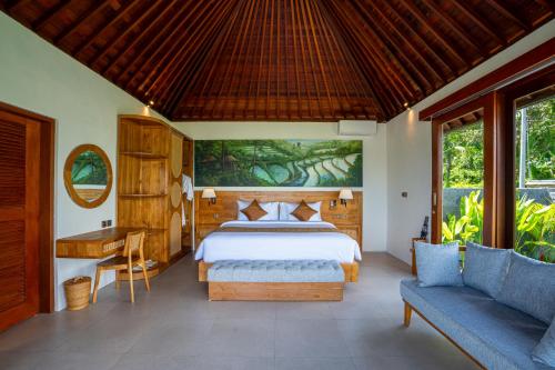 a bedroom with a bed and a desk and a couch at Gauri Villas Sidemen in Sidemen