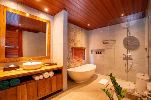 a bathroom with a toilet and a sink and a tub at Gauri Villas Sidemen in Sidemen