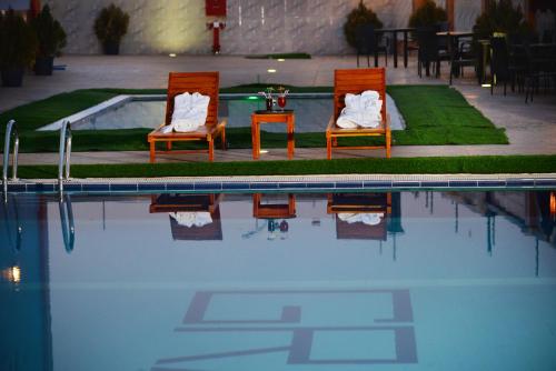 two chairs sitting next to a swimming pool at Grand Pela Hotel & Suites in Abuja