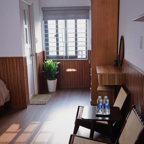 a living room with a table and two bottles of water at Mộng Homestay in Huế in Thôn Trường Giang