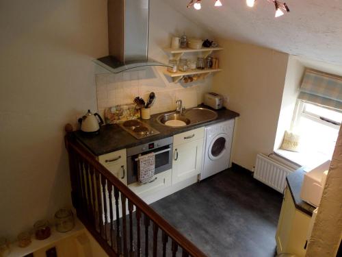 a kitchen with a sink and a washing machine at Burnthwaite Cottage in Windermere
