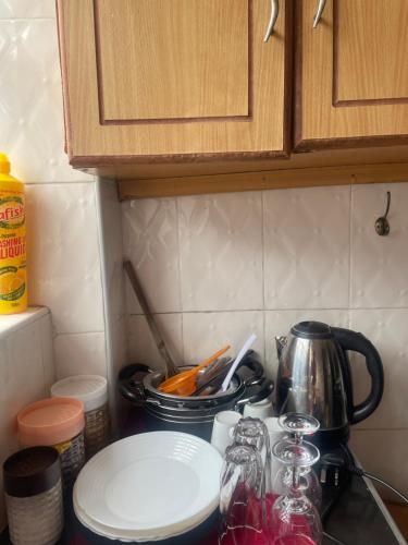 a kitchen counter with a stove top with plates and utensils at Nadine's Enclave in Kisii