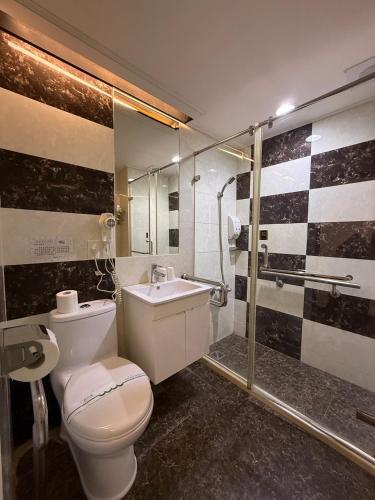 ein Badezimmer mit Toilette, Waschbecken und Dusche in der Unterkunft Dreamer Hotel in Budai
