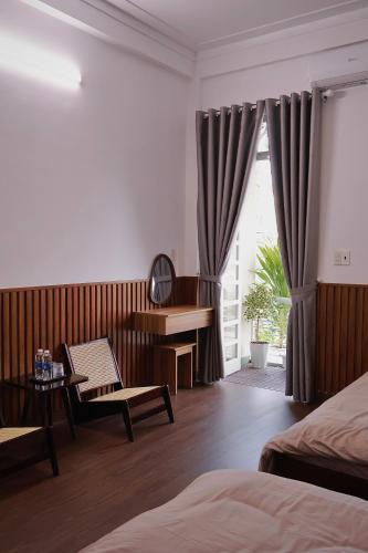 a hotel room with a bed and a desk and a window at Mộng Homestay in Huế in Thôn Trường Giang