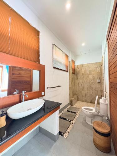a bathroom with a sink and a toilet at De Padma Gili Air in Gili Islands