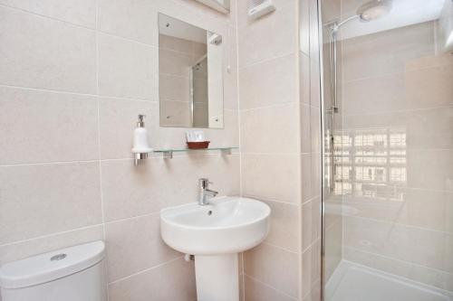 La salle de bains est pourvue de toilettes, d'un lavabo et d'une douche. dans l'établissement The Dickens Bar & Inn, à Scarborough