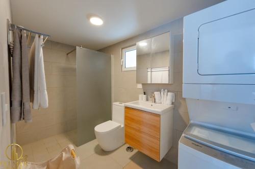a bathroom with a white toilet and a sink at Aura Sosua Ocean Village in Sosúa