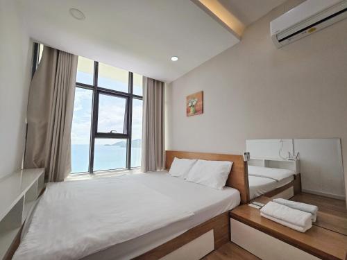 a small room with a bed and a window at Gold Ocean Apartment Nha Trang in Nha Trang