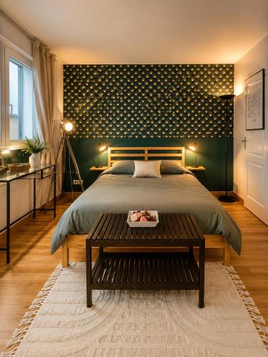 a bedroom with a large bed and a table at Green Balcony Lille Hyper centre in Lille