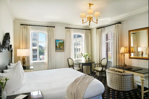a hotel room with a bed and a desk and chairs at French Quarter Inn in Charleston