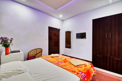 Rams Guest House Near Sree Chithra and RCC في تريفاندروم: غرفة نوم مع سرير كبير وخزانة بنية اللون