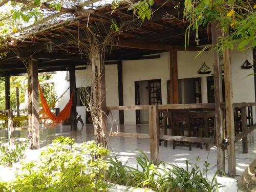 an outside view of a house with tables and chairs at Pousada Barra do Mundaú in Lavagem