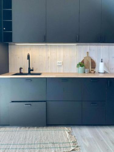 a kitchen with blue cabinets and a sink at Panoramic Cabin With Sea View On Randøy in Hjelmeland
