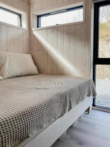 a bed in a small room with a window at Panoramic Cabin With Sea View On Randøy in Hjelmeland