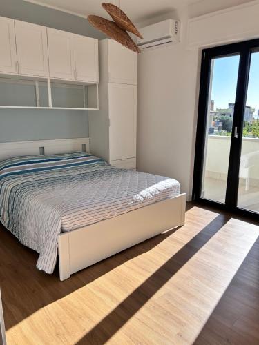 a bedroom with a bed and a large window at A casa di Chiara in Isca sullo Ionio