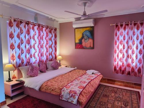 a bedroom with a large bed with red curtains at The Nagri Resort in Pālampur