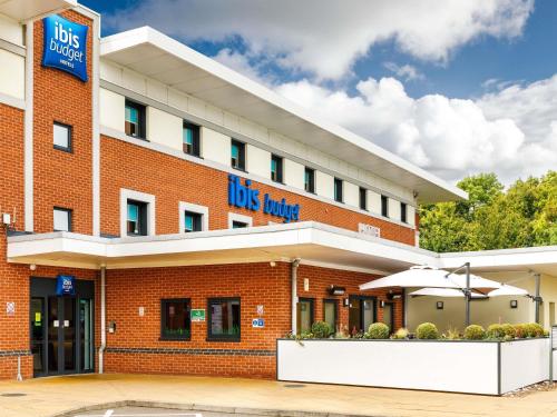 a red brick hotel with an umbrella in front of it at ibis budget Leicester in Leicester