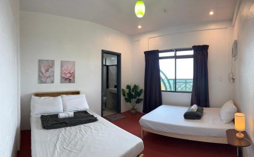a bedroom with two beds and a window at MC Mountain Home in Tagaytay