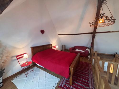 a bedroom with a red bed in a attic at Bruyère en Fleur in Clugnat