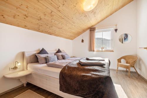 a bedroom with a large bed with a wooden ceiling at Ferienhaus Geyerbad mit Sauna in Meßstetten