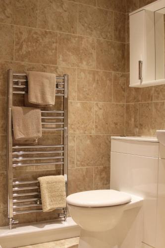 a bathroom with a toilet and a towel rack at Villa Farm York in York