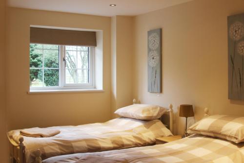 two beds in a room with a window at Villa Farm York in York