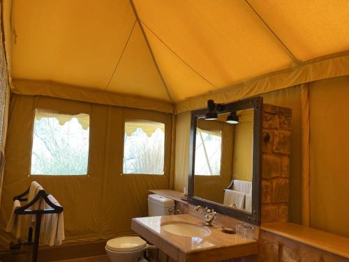 a bathroom with a tent with a sink and a toilet at MANVĀR SEVAN, THE DESERT CAMP in Shaitrāwa