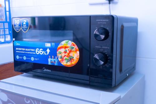 a microwave oven with a pizza on the door at Benson waweru APPARTMENT in Kakamega