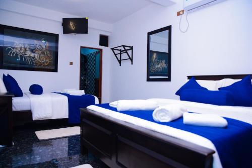 a room with two beds with blue and white at Thenulya Resort in Ella
