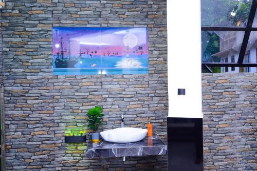 a bathroom with a sink on a stone wall at Thenulya Resort in Ella