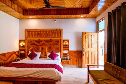 a bedroom with a bed and a wooden ceiling at The Royal Pinewood in Kasol