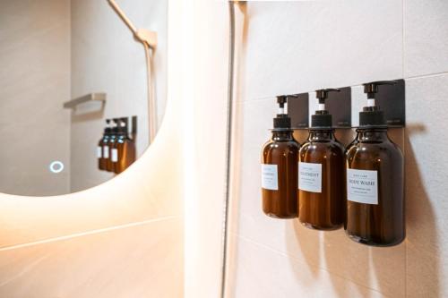 a group of bottles of essential oils in front of a mirror at 가치스테이 강서 in Seoul