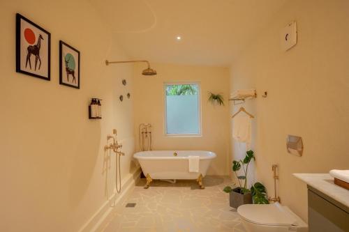 a bathroom with a tub and a toilet at SaffronStays Oslo in Anjuna