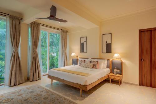a bedroom with a bed and a large window at SaffronStays Oslo in Anjuna